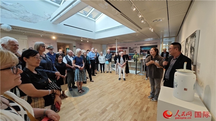 參展人、景德鎮(zhèn)陶瓷大學(xué)美術(shù)學(xué)院副院長邵長宗（右一）向來賓介紹參展作品。人民網(wǎng)記者 殷淼攝