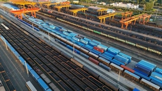 這是2024年8月14日在黑龍江綏芬河鐵路口岸集裝箱換裝場拍攝的集裝箱換裝作業(yè)現(xiàn)場（無人機(jī)照片）。今年前七個(gè)月，綏芬河鐵路口岸開行中歐班列573列，運(yùn)量達(dá)55246標(biāo)箱，同比分別增長23%和18%，班列數(shù)量持續(xù)保持高位運(yùn)行。