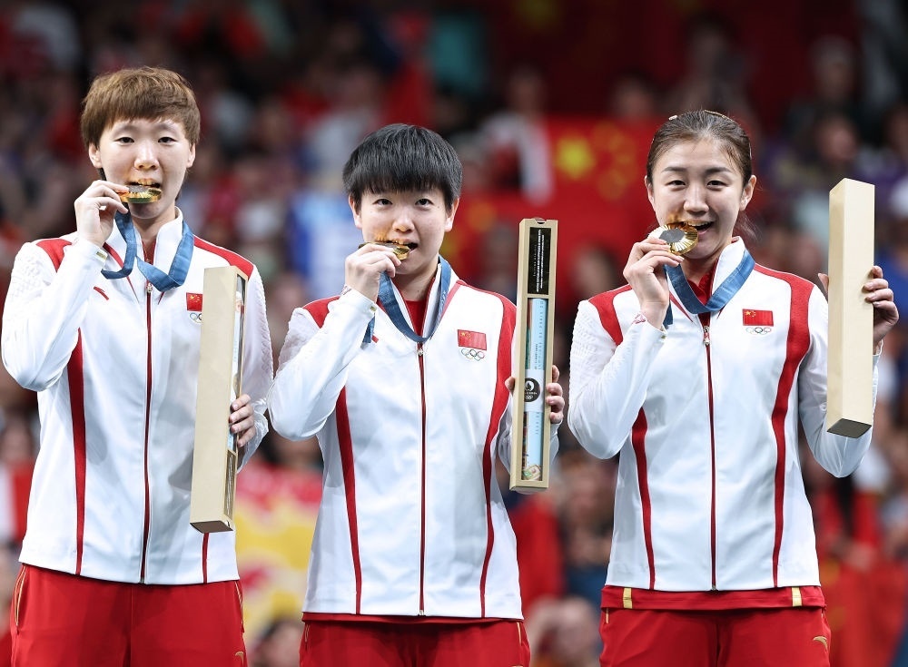 冠軍中國隊選手王曼昱、孫穎莎、陳夢（從左至右）在巴黎奧運會乒乓球女子團體頒獎儀式上（2024年8月10日攝）。新華社記者 王東震 攝