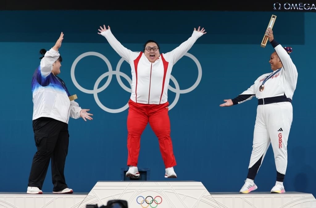 中國選手李雯雯（中）在巴黎奧運會舉重女子81公斤以上級頒獎儀式中登上領獎臺（2024年8月11日攝）。新華社記者 楊磊 攝