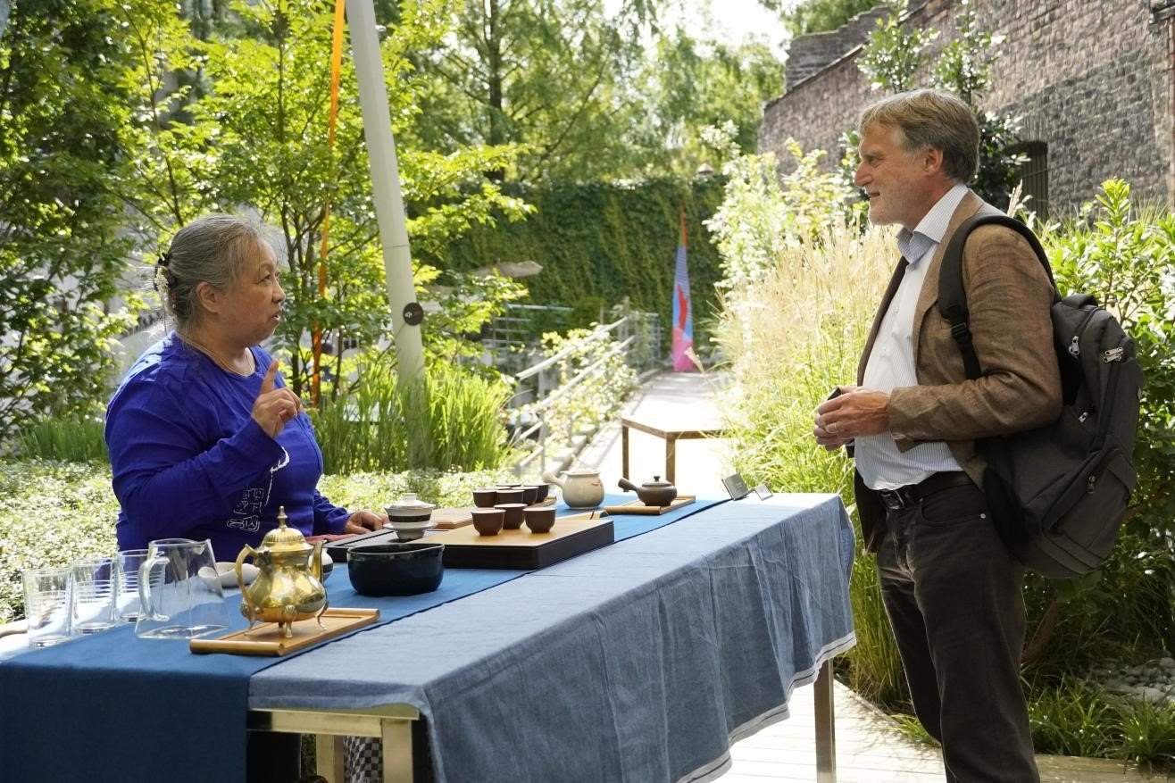 在博物館的戶外花園來賓品味中國茶藝。比利時(shí)維他命文化傳媒供圖