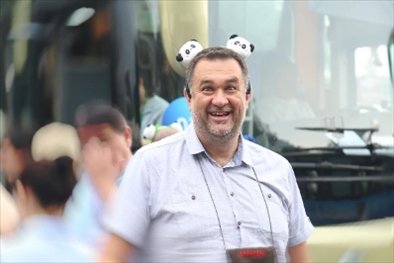 參訪熊貓谷前，塞爾維亞“一帶一路”研究所所長(zhǎng)博揚(yáng)·拉利奇戴上熊貓頭飾。（李佩藺 攝）