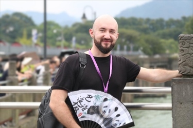 俄羅斯塔斯社執(zhí)行編輯葉夫根尼·扎多羅日內(nèi)在都江堰魚嘴拍照留念。（李佩藺 攝）