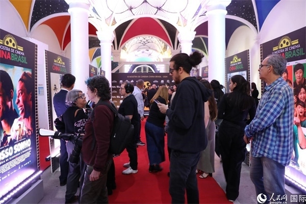 為期4天的第三屆中國(guó)－巴西電影展期間，來自中巴兩國(guó)的14部參展影片受到巴西電影愛好者和社會(huì)各界人士好評(píng)，圖為當(dāng)?shù)赜^眾在影展舉辦地巴西里約熱內(nèi)盧勞拉—阿爾維姆文化之家的迎賓廳欣賞參展電影海報(bào)。 人民網(wǎng)記者 陳一鳴攝