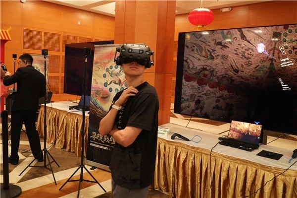 1、在本次活動的展覽現(xiàn)場，敦煌研究院與騰訊展示了“數(shù)字藏經(jīng)洞”和“尋境敦煌”等創(chuàng)新互動產(chǎn)品。圖為當(dāng)?shù)孛癖娡ㄟ^VR虛擬游覽洞窟。 人民網(wǎng)記者 李志偉攝