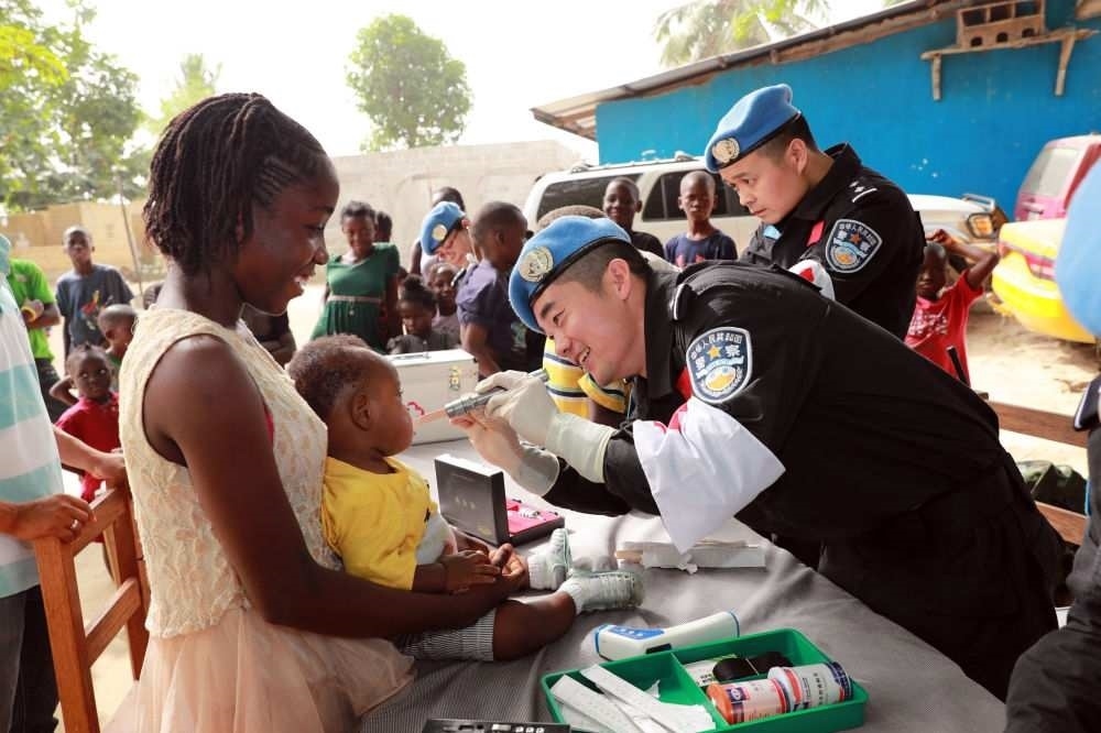 2017年12月28日，在利比里亞蒙羅維亞，中國(guó)維和警察防暴隊(duì)醫(yī)療人員為兒童做口腔檢查。