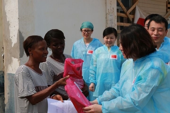 2015年4月4日，在位于塞拉利昂首都弗里敦市郊的中塞友好醫(yī)院埃博拉診療中心，中國第四批援塞醫(yī)療隊副隊長邵蔚（右前）向被治愈的埃博拉出血熱患者贈送禮物。新華社發(fā)（祖榮強 攝）