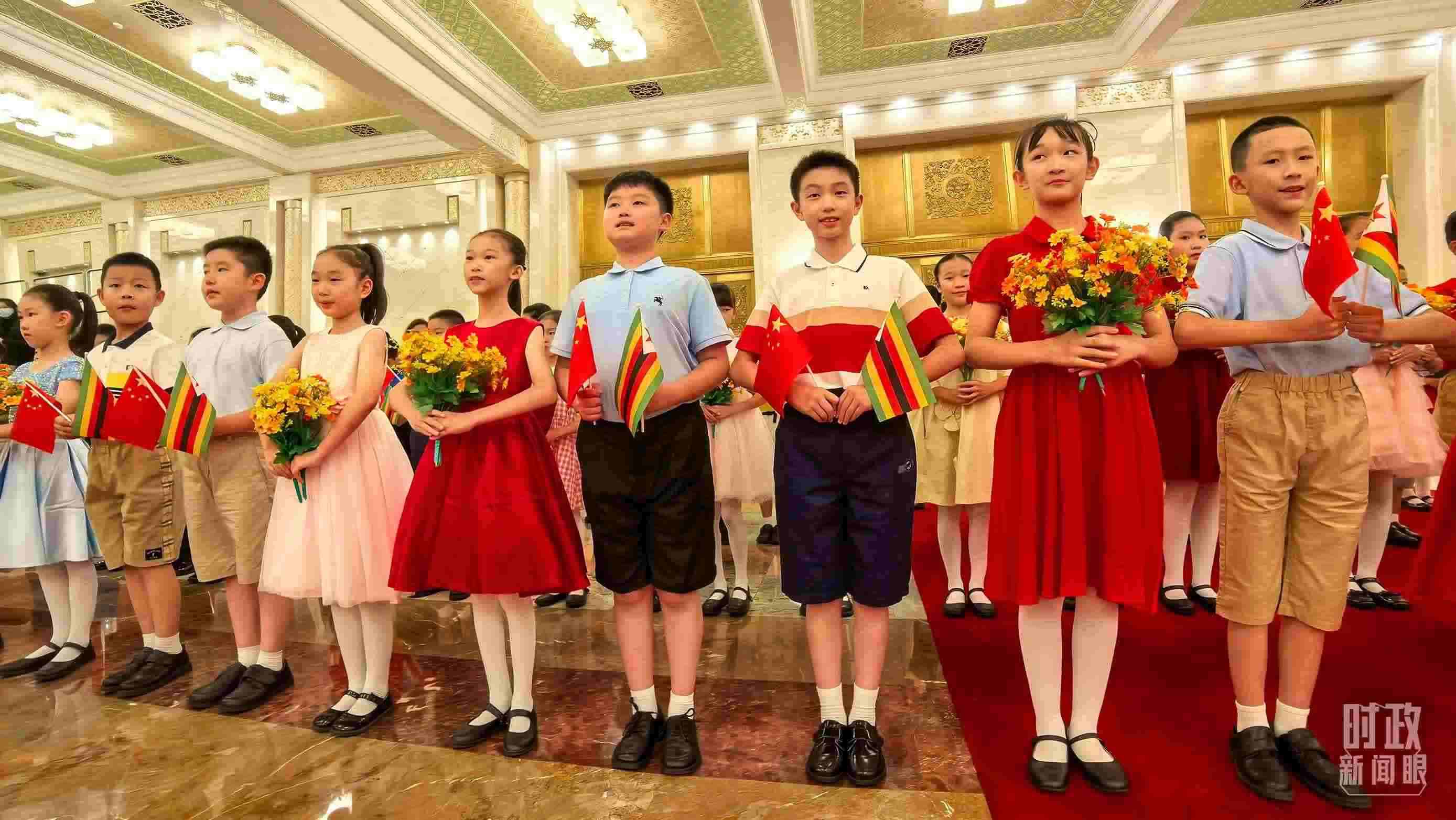 △現(xiàn)場歡迎津巴布韋總統(tǒng)訪華的青少年。（總臺央視記者鐘銳拍攝）