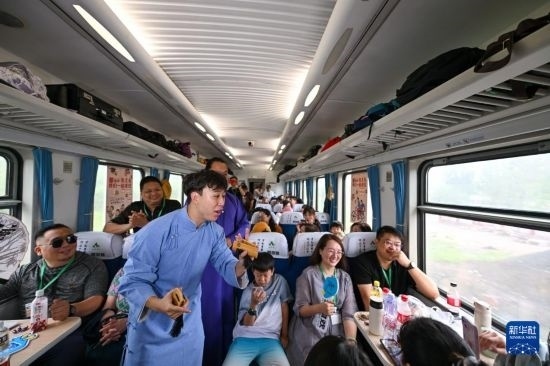 9月7日，相聲演員在S910列車上為旅客表演快板。