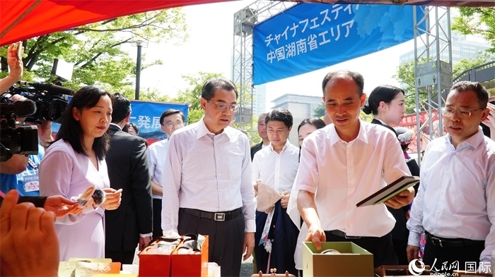 湖南展位工作人員向中國(guó)駐日本大使吳江浩介紹特色文創(chuàng)產(chǎn)品。人民網(wǎng) 蔣曉辰攝