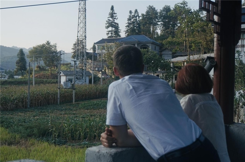 望得見(jiàn)山，看得見(jiàn)水，記得住鄉(xiāng)愁。每個(gè)人心中都有一個(gè)屬于自己的“花茂村”，在這方心田，走遍千山萬(wàn)水，鄉(xiāng)音未改鬢毛衰。吉爾吉斯斯坦《比什凱克晚報(bào)》第一副總編輯妮娜·尼奇博洛娃與《中國(guó)與俄羅斯》雜志社社長(zhǎng)奧列格·別列日內(nèi)赫攝在花茂村民居屋檐下并肩佇立，眺望山水，尋覓鄉(xiāng)愁。（李光裕攝）