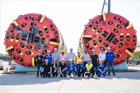 中外員工在盾構(gòu)機(jī)前合影。中國電建供圖