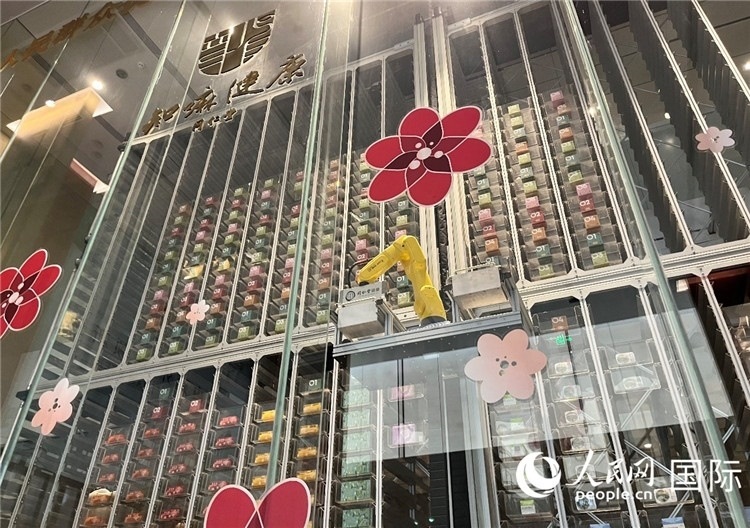 6. 機(jī)械臂正在取貨。（人民網(wǎng)記者陳思 攝）