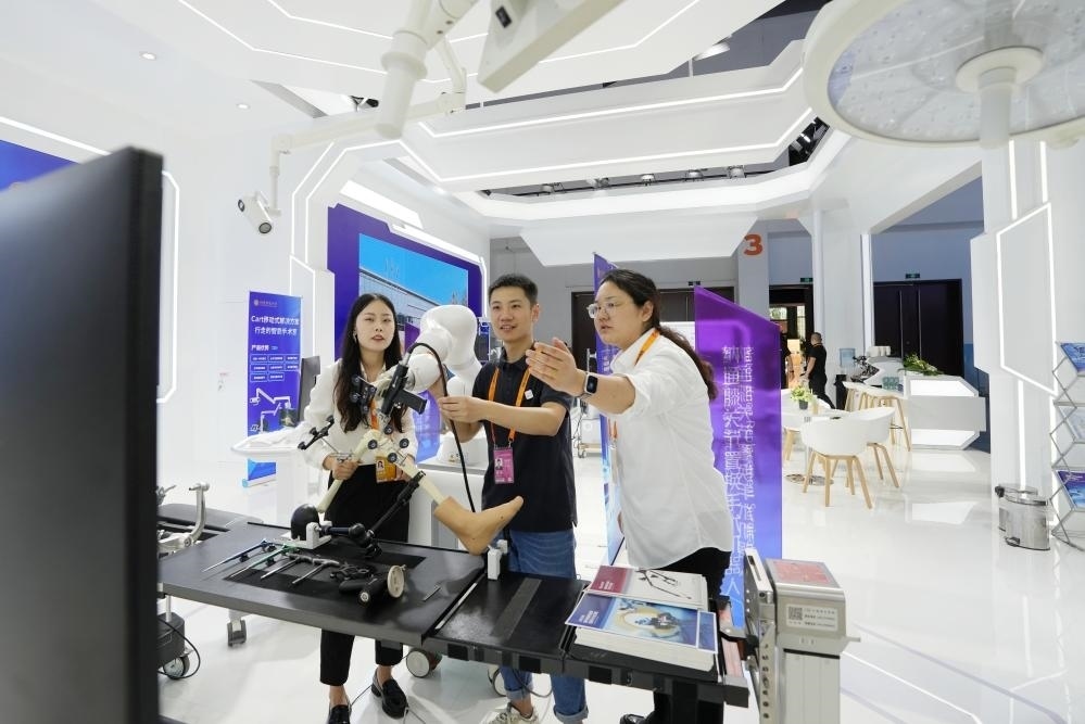 9月11日，一位媒體記者（中）在2024年服貿(mào)會(huì)國(guó)家會(huì)議中心會(huì)場(chǎng)體驗(yàn)北京納通科技集團(tuán)有限公司的膝關(guān)節(jié)置換手術(shù)機(jī)器人。新華社記者鞠煥宗 攝