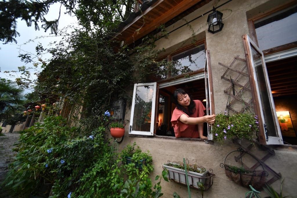 8月29日，在福建省屏南縣熙嶺鄉(xiāng)，龍?zhí)洞濉靶麓迕瘛泵泛暝诖蚶碜约航?jīng)營的民宿外墻裝飾花盆。新華社記者姜克紅 攝