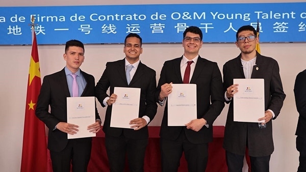 當地時間9月13日，40名哥倫比亞青年與中企承建運營的波哥大地鐵一號線項目簽約，不久將前往中國進行為期15個月的專業(yè)地鐵知識培訓。圖為部分學員在簽約儀式上展示所簽的協(xié)議。 波哥大地鐵一號線項目供圖