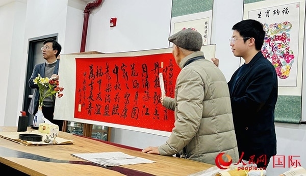 旅秘書法家向現(xiàn)場(chǎng)觀眾展示書法作品。人民網(wǎng)記者 宋亦然攝