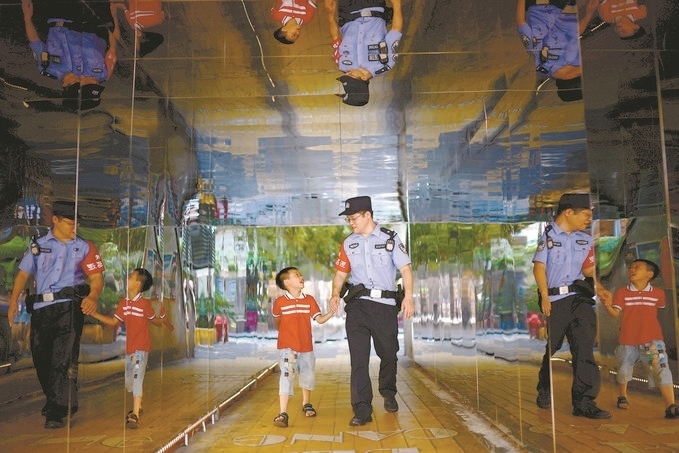 ?7月16日，重慶市公安局江北區(qū)分局一名民警在巡邏途中遇到一個獨自玩耍的小男孩，民警將其送回家。王洪平攝