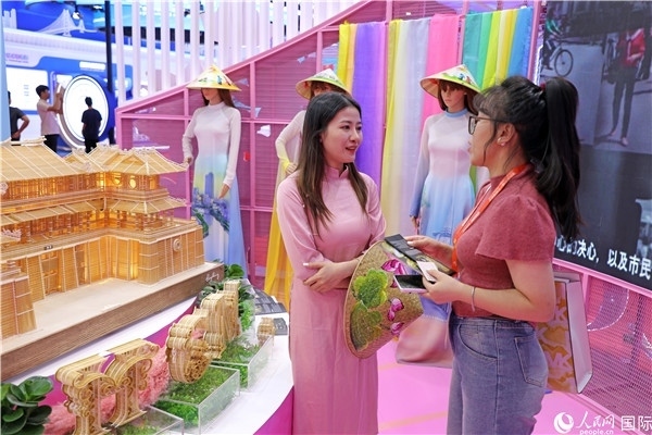 參觀者在東博會(huì)越南展區(qū)同工作人員咨詢交談。人民網(wǎng)記者 趙益普攝