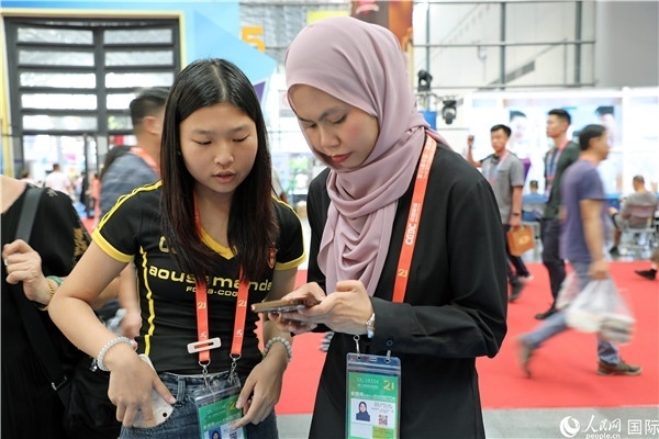 東博會(huì)現(xiàn)場(chǎng)，馬來西亞展商在同中方工作人員交談。人民網(wǎng)記者 趙益普攝