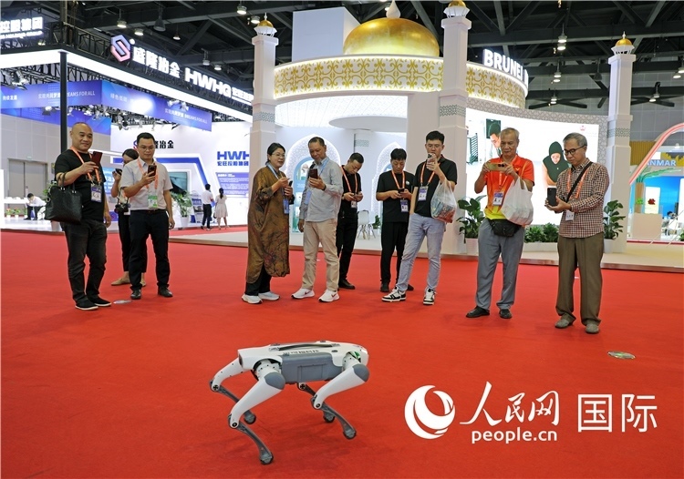 東博會(huì)上，觀眾正在參觀一只機(jī)器狗。綠色能源、新能源汽車、綠色農(nóng)產(chǎn)品等成為本屆東博會(huì)觀眾關(guān)注的焦點(diǎn)。人民網(wǎng)記者 趙益普攝