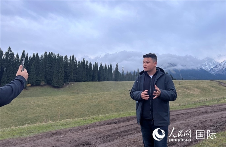 在庫(kù)爾德寧，吾買爾江被雪山美景震撼，即興錄制了短視頻作品。人民網(wǎng)記者曾書柔攝