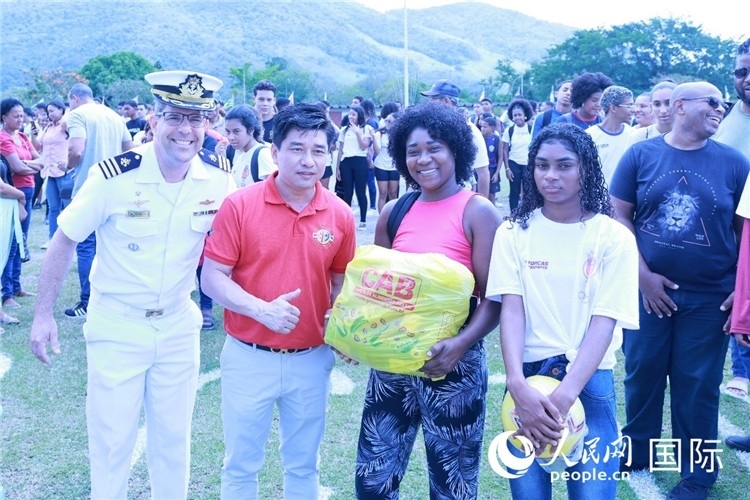 巴西中國浙江商會會長鄭俠茂向巴西貧困社區(qū)兒童及家庭捐贈基礎食品籃子和足球。人民網(wǎng)記者陳海琪 攝