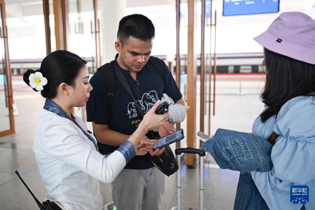 10月12日，在老撾萬象中老鐵路萬象站，工作人員檢驗乘客車票。新華社記者 程一恒 攝