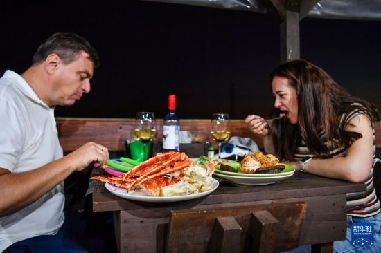 9月2日，食客們?cè)诙砹_斯符拉迪沃斯托克的一家餐館品嘗帝王蟹。新華社記者 曹陽(yáng) 攝