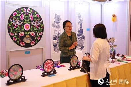 青海非遺文化傳承人向嘉賓介紹展品。人民網(wǎng)實習(xí)生姚欣可攝