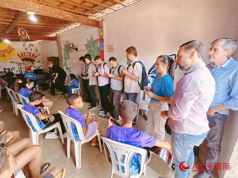  受益于中國企業(yè)的“青少年成長”項目，700多名當(dāng)?shù)厍嗌倌甑囊魳泛妥闱驂粝氩迳狭顺岚?。圖為聯(lián)合采訪團正在采訪參加音樂培訓(xùn)的孩子們。 人民網(wǎng)記者 陳一鳴攝