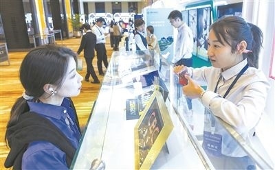 在北京麗澤商務(wù)區(qū)，工作人員（右一）介紹數(shù)字人民幣SIM卡硬錢包。新京報記者 陶冉攝