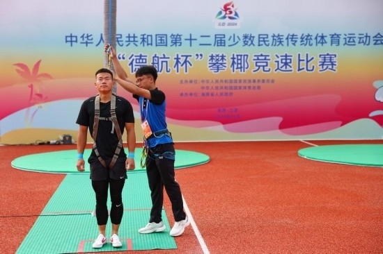 11月23日，工作人員為上海隊(duì)選手付樂樂（左）系安全繩。新華社記者 楊植森 攝