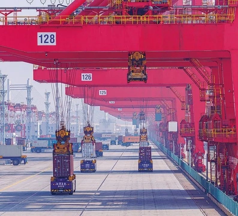 共建“一帶一路”國(guó)家在工作制度對(duì)接、技術(shù)標(biāo)準(zhǔn)協(xié)調(diào)、檢驗(yàn)結(jié)果互認(rèn)等方面強(qiáng)化合作、統(tǒng)一標(biāo)準(zhǔn)，貿(mào)易自由化便利化水平不斷提升。上海洋山港海關(guān)對(duì)接共建國(guó)家進(jìn)出口貨物相關(guān)標(biāo)準(zhǔn)，推動(dòng)通關(guān)一體化方式申報(bào)，提升通關(guān)效率。圖為無(wú)人駕駛的全自動(dòng)導(dǎo)引車(chē)在洋山港穿梭往來(lái)，搬運(yùn)集裝箱。王初 攝