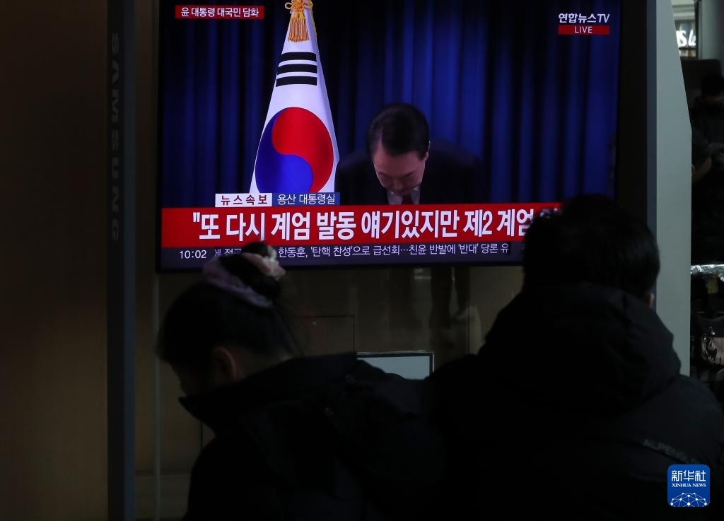 12月7日，在韓國首爾火車站，民眾觀看總統(tǒng)尹錫悅發(fā)表講話的電視畫面。新華社記者 姚琪琳 攝