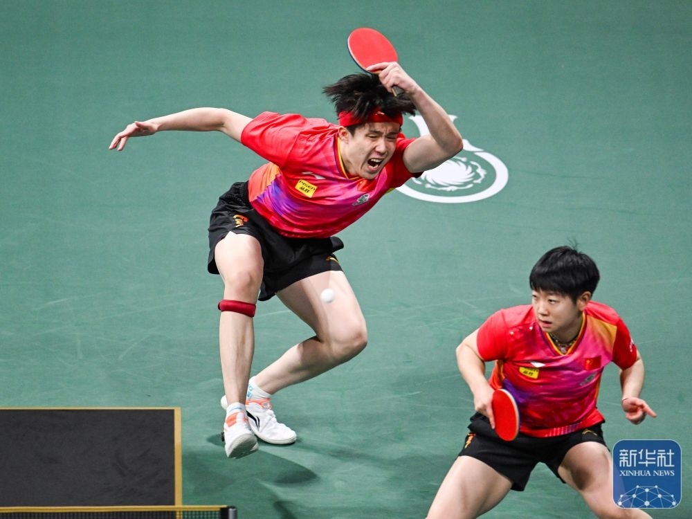↑中國隊(duì)組合王楚欽（左）/孫穎莎在混雙比賽中。新華社記者 王曦 攝