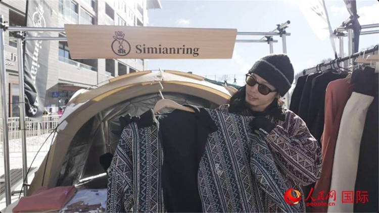 藤田周正在展示自己設(shè)計(jì)的滑雪服。人民網(wǎng)記者 袁蒙攝