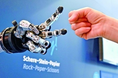 在德國(guó)漢諾威工博會(huì)上，參觀者與一款智能機(jī)器人進(jìn)行“石頭剪子布”游戲。新華社發(fā)