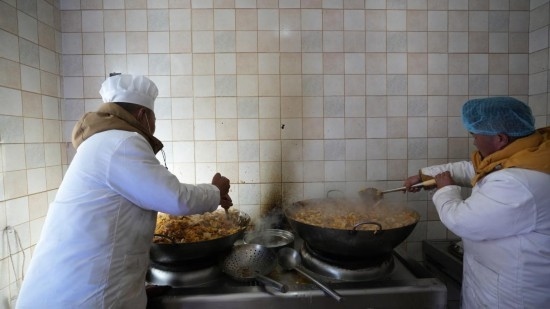 1月14日，服務(wù)隊(duì)的兩名廚師正在為村民們做午飯。新華社記者 邱星翔 攝