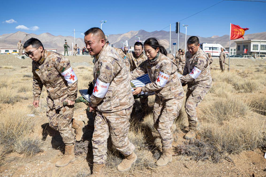 1月9日，日喀則定日縣長所鄉(xiāng)，西藏軍區(qū)總醫(yī)院醫(yī)療隊(duì)隊(duì)員將受傷村民用擔(dān)架從救護(hù)車準(zhǔn)備抬上直升機(jī)，轉(zhuǎn)運(yùn)至拉薩的西藏軍區(qū)總醫(yī)院救治。人民日報(bào)記者張武軍攝