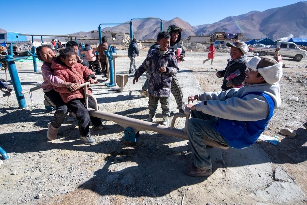 1月11日，在定日縣措果鄉(xiāng)塘仁村安置點(diǎn)，西藏星光社會(huì)工作服務(wù)中心志愿者和孩子們一起玩耍，進(jìn)行災(zāi)后心理疏導(dǎo)。人民網(wǎng)記者 翁奇羽攝