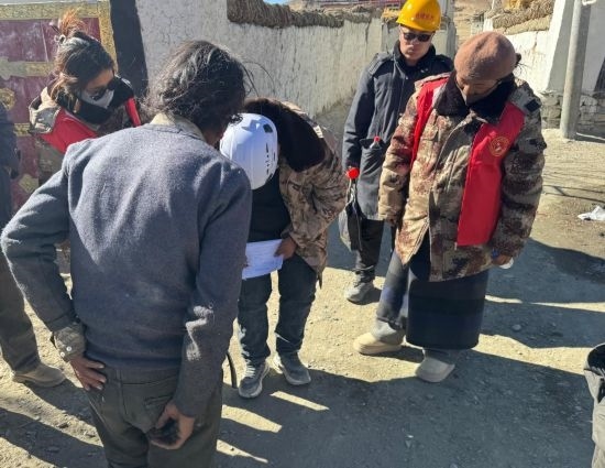 1月13日，次旺（右一）陪同工作組走訪村莊，評估房屋受損程度。新華社發(fā)