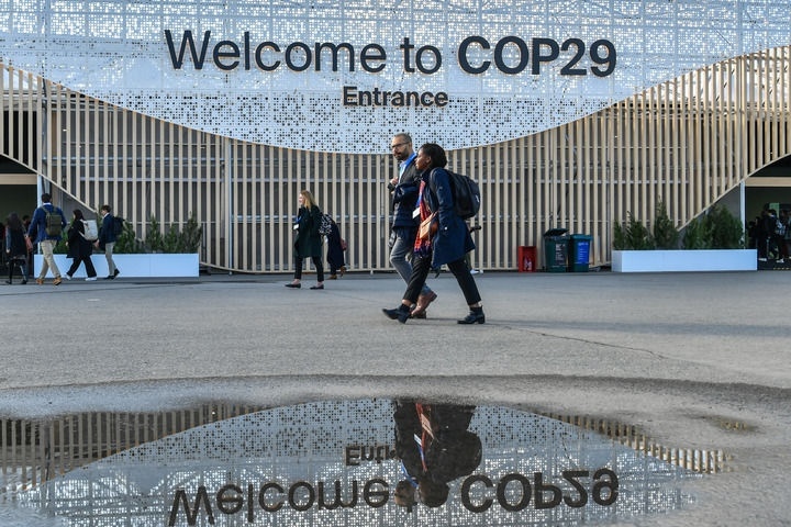 2024年11月15日，在阿塞拜疆首都巴庫(kù)，人們經(jīng)過聯(lián)合國(guó)氣候變化巴庫(kù)大會(huì)的會(huì)場(chǎng)。新華社記者 曹陽 攝