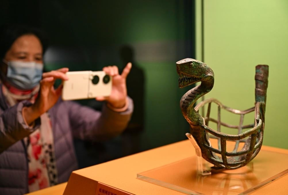 1月14日，觀眾在上海博物館蛇年迎春展拍攝展品蛇綱網(wǎng)狀銅器。新華社發(fā)（陳浩明攝）