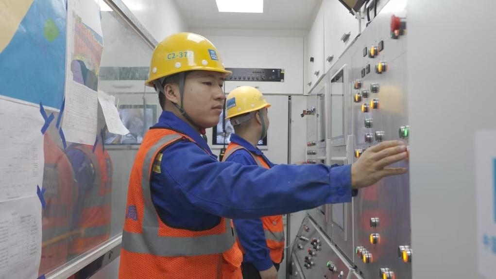 盾構(gòu)司機(jī)何曉波在駕駛室內(nèi)調(diào)試盾構(gòu)機(jī)參數(shù)。（劉芬攝）