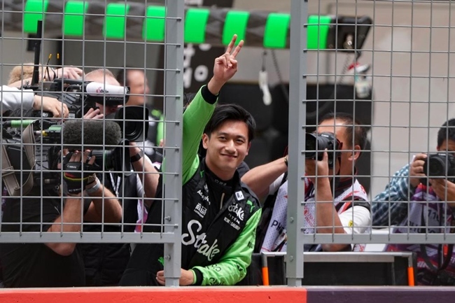 2024年4月19日，索伯車(chē)隊(duì)中國(guó)車(chē)手周冠宇（中）在練習(xí)賽前向觀眾致意。當(dāng)日，F(xiàn)1中國(guó)大獎(jiǎng)賽在上海開(kāi)賽。中國(guó)車(chē)手周冠宇主場(chǎng)首秀參賽。新華社記者 夏一方攝