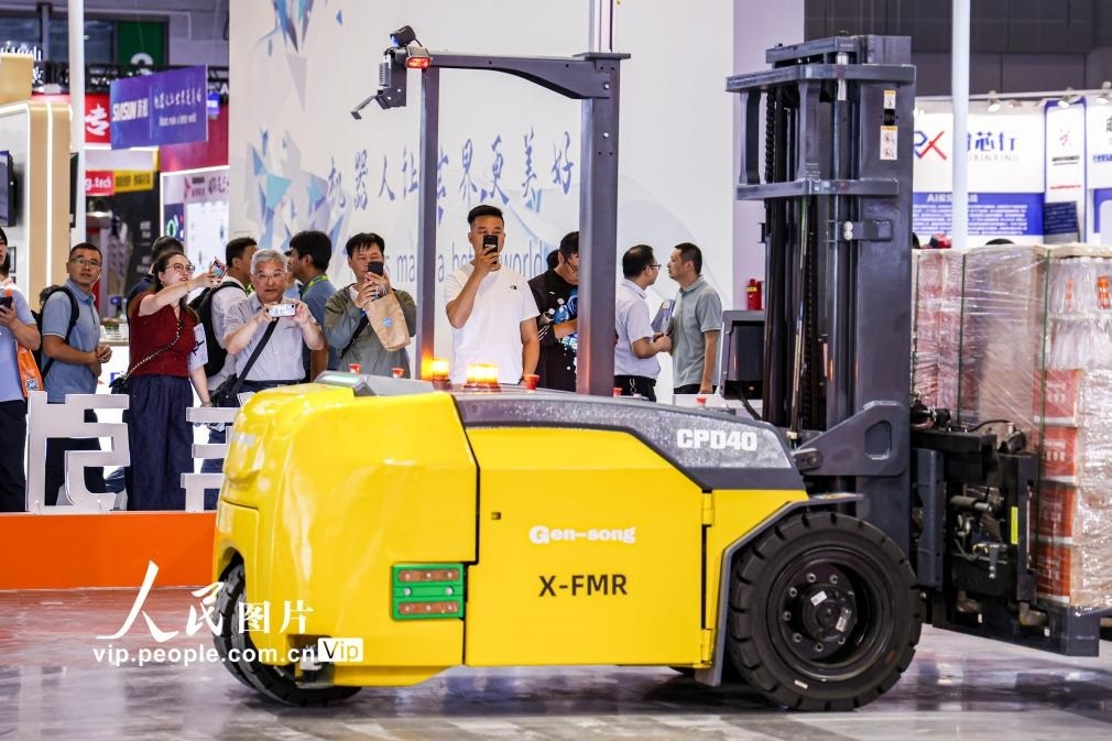 第24屆中國(guó)工博會(huì)現(xiàn)場(chǎng)，觀眾觀看叉取機(jī)器人作業(yè)演示。王初攝（人民圖片網(wǎng)）