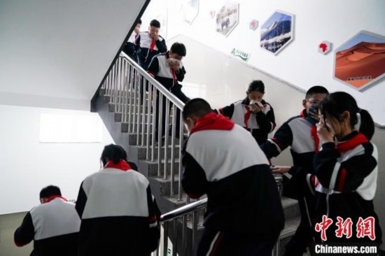  圖為學(xué)生們進(jìn)行應(yīng)急疏散演練。中新社記者 趙宇航 攝