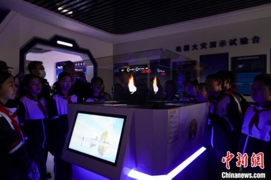 圖為學(xué)生們參觀道里區(qū)消防救援大隊消防科普體驗館內(nèi)幻影成像燃燒三要素實驗臺。中新社記者 趙宇航 攝