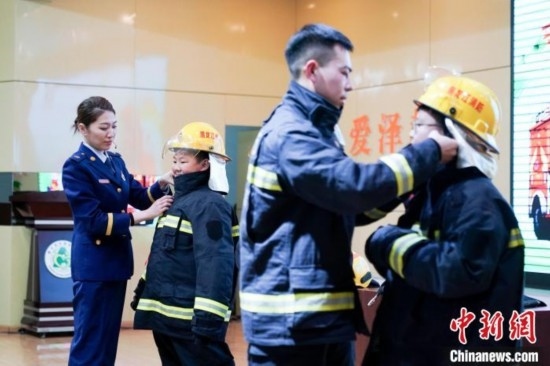 圖為學(xué)生們現(xiàn)場穿戴消防頭盔和戰(zhàn)斗服。中新社記者 趙宇航 攝